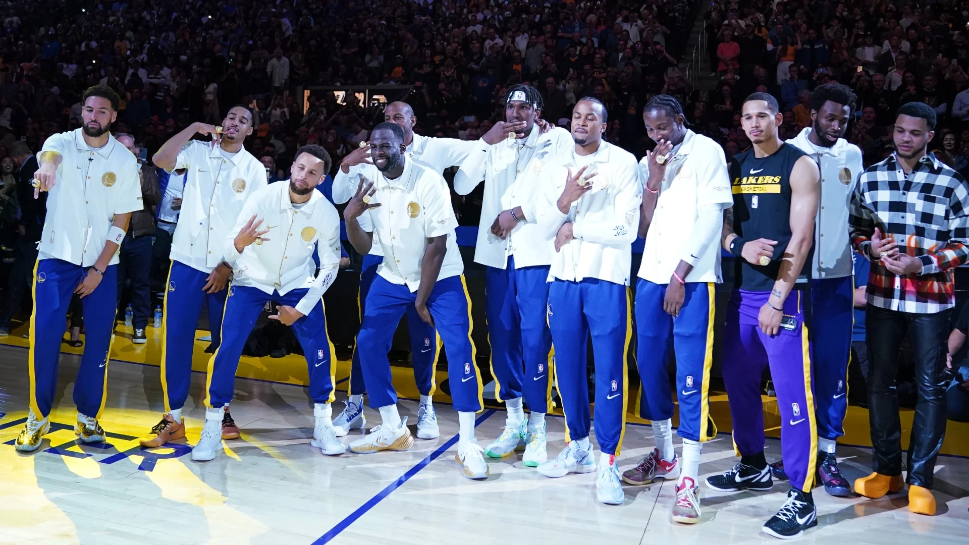Golden State Warriors players displaying their championship rings at Chase Center in 2022