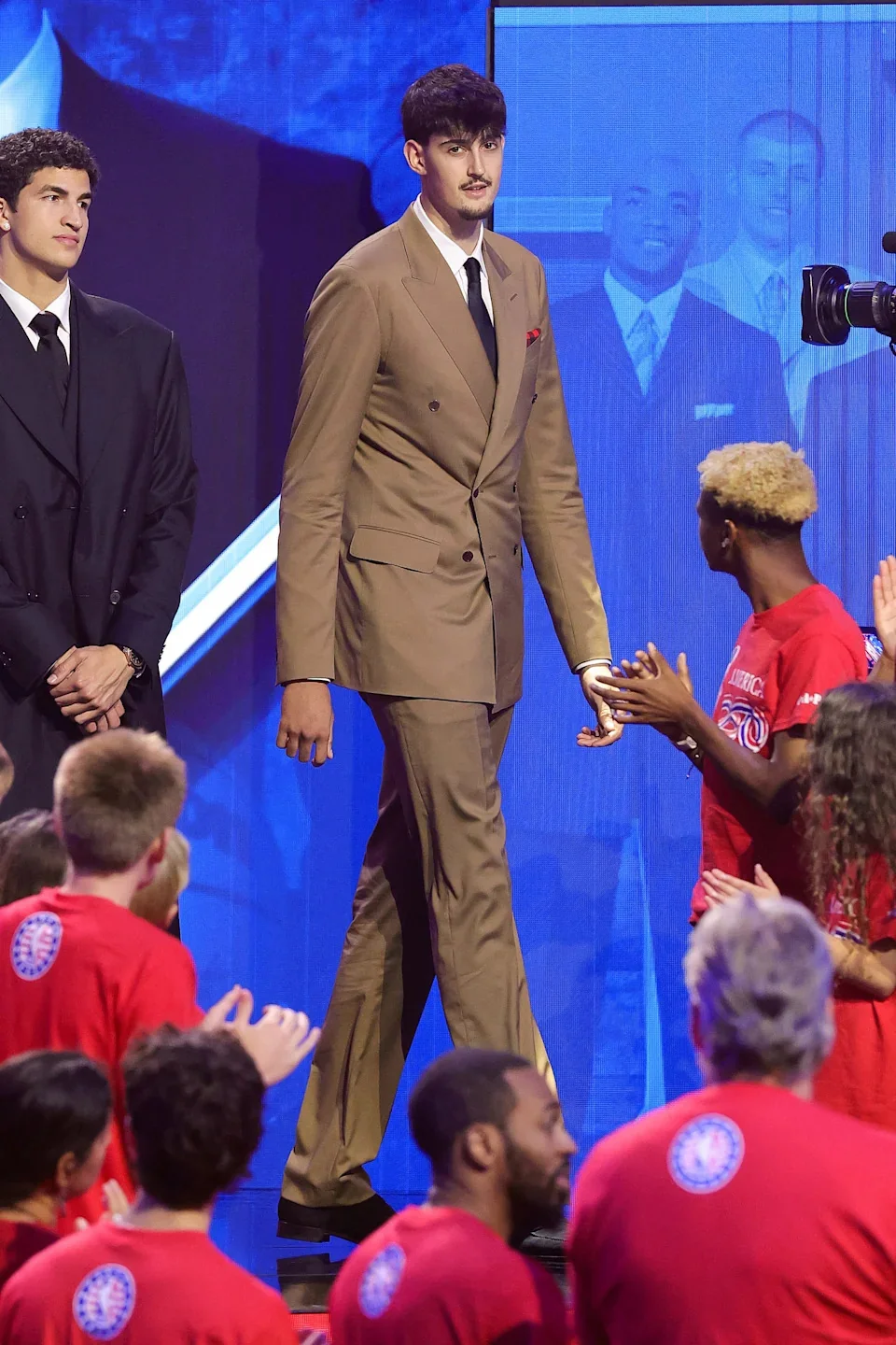 An NBA prospect walking to the stage after being selected on draft night