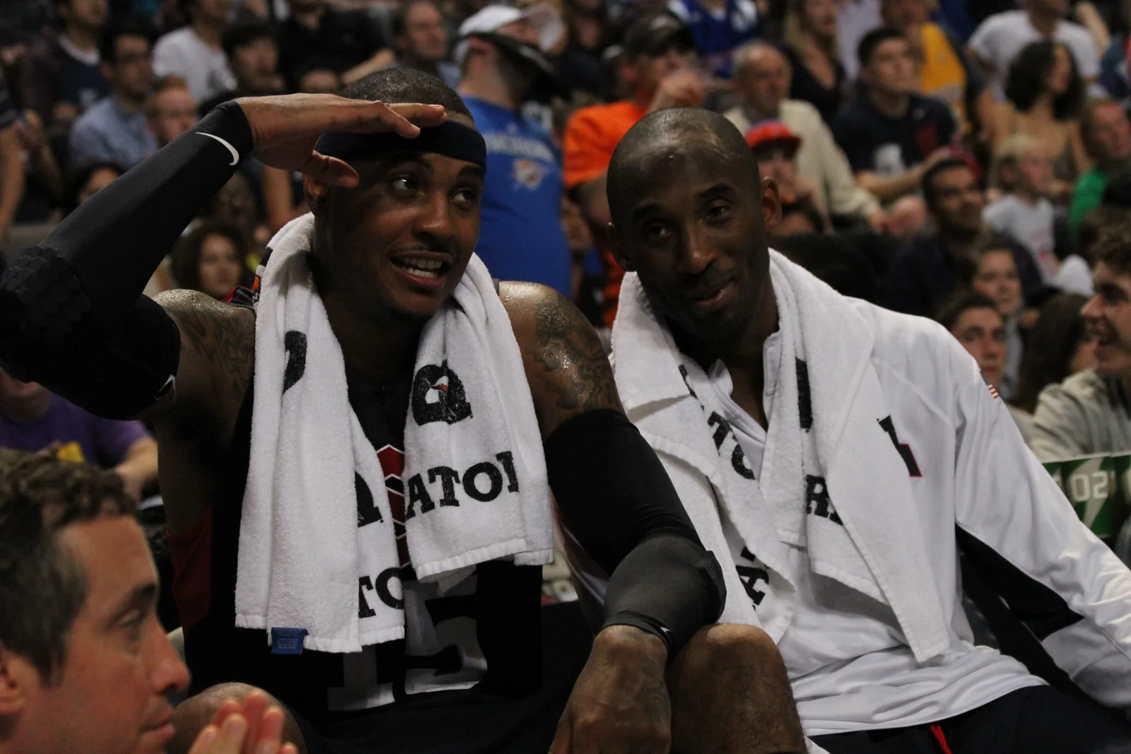 Veteran NBA players Carmelo Anthony and Kobe Bryant seated on a basketball bench