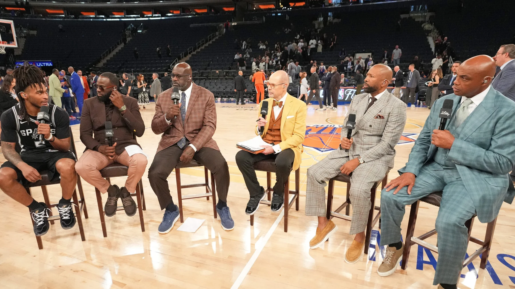 Inside the NBA panelists Shaquille O'Neal, Ernie Johnson, Kenny Smith and Charles Barkley seated courtside
