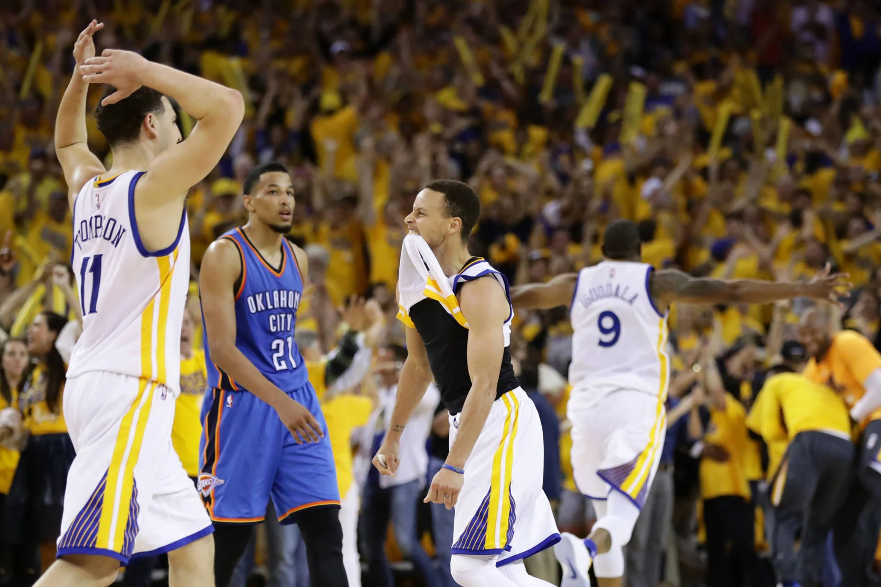Golden State Warriors players celebrating together on the court during a playoff game